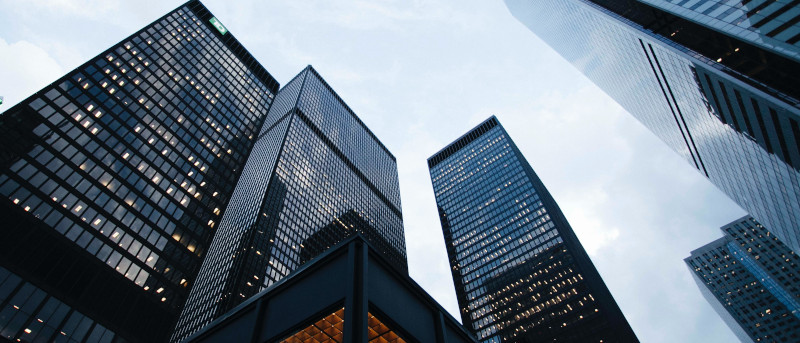 Photo looking up at the sky through tall office buildings