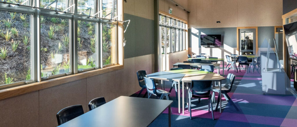 Photo of empty sunlit classroom with open windows